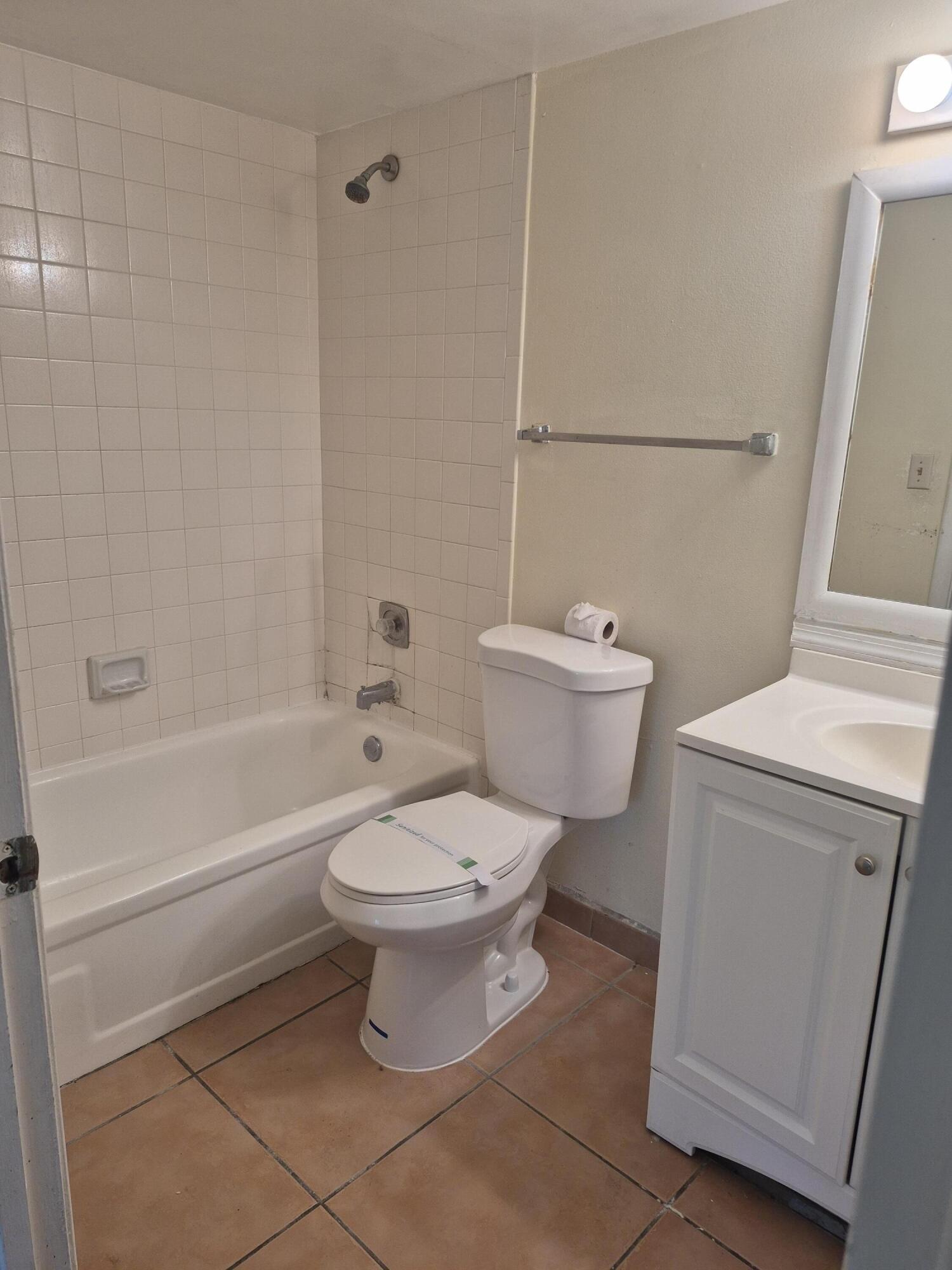 2050 North Congress Avenue, Unit 407 West Palm Beach, FL 33401 - Photo 10 of 16 a white toilet sitting next to a bath tub
