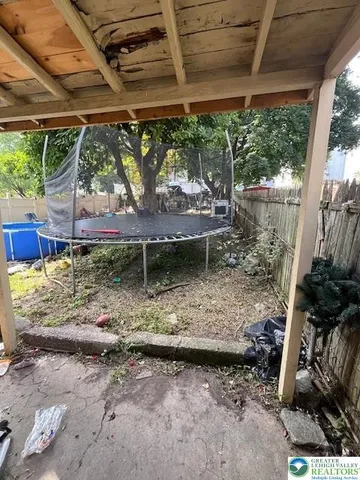 a view of a yard with table and chairs under an umbrella