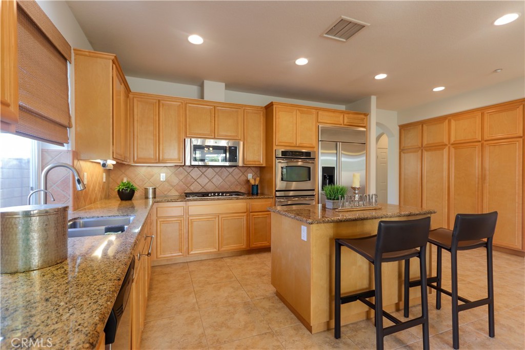 327 Tomko Way Placentia, CA 92870 - Photo 12 of 47 a kitchen with stainless steel appliances granite countertop a stove top oven a sink dishwasher and white cabinets with wooden floor