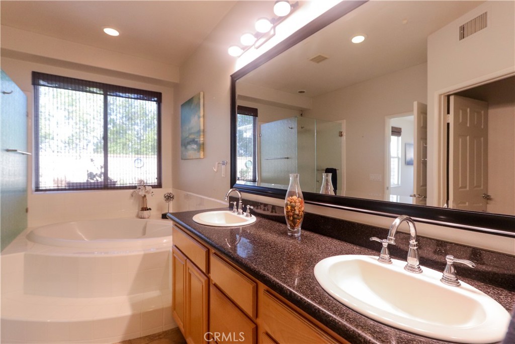 327 Tomko Way Placentia, CA 92870 - Photo 26 of 47 a bathroom with a double vanity sink a mirror and a bathtub