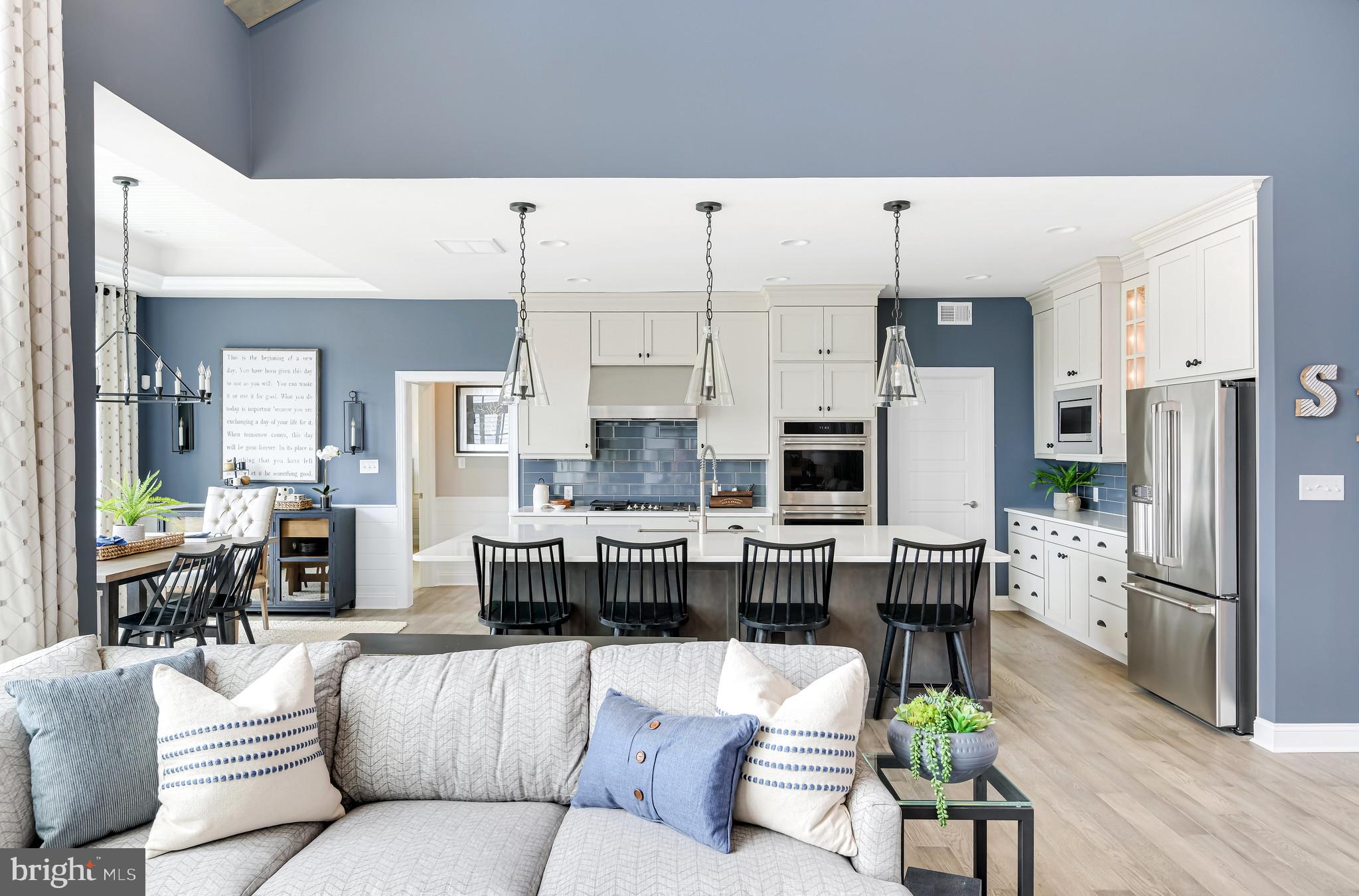 21810 Eastbridge Loop Lewes, DE 19958 - Photo 9 of 32 a living room with stainless steel appliances kitchen island granite countertop furniture and a view of kitchen