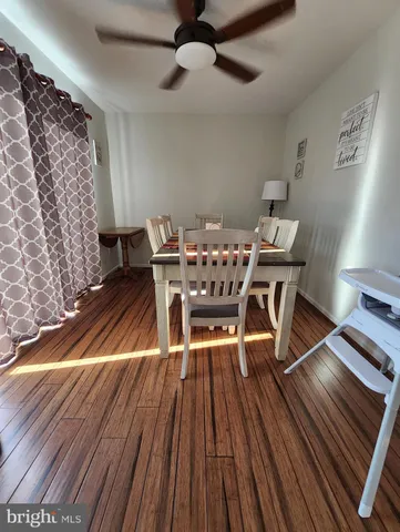 a dining room with wooden floor a chandelier a wooden table and chairs