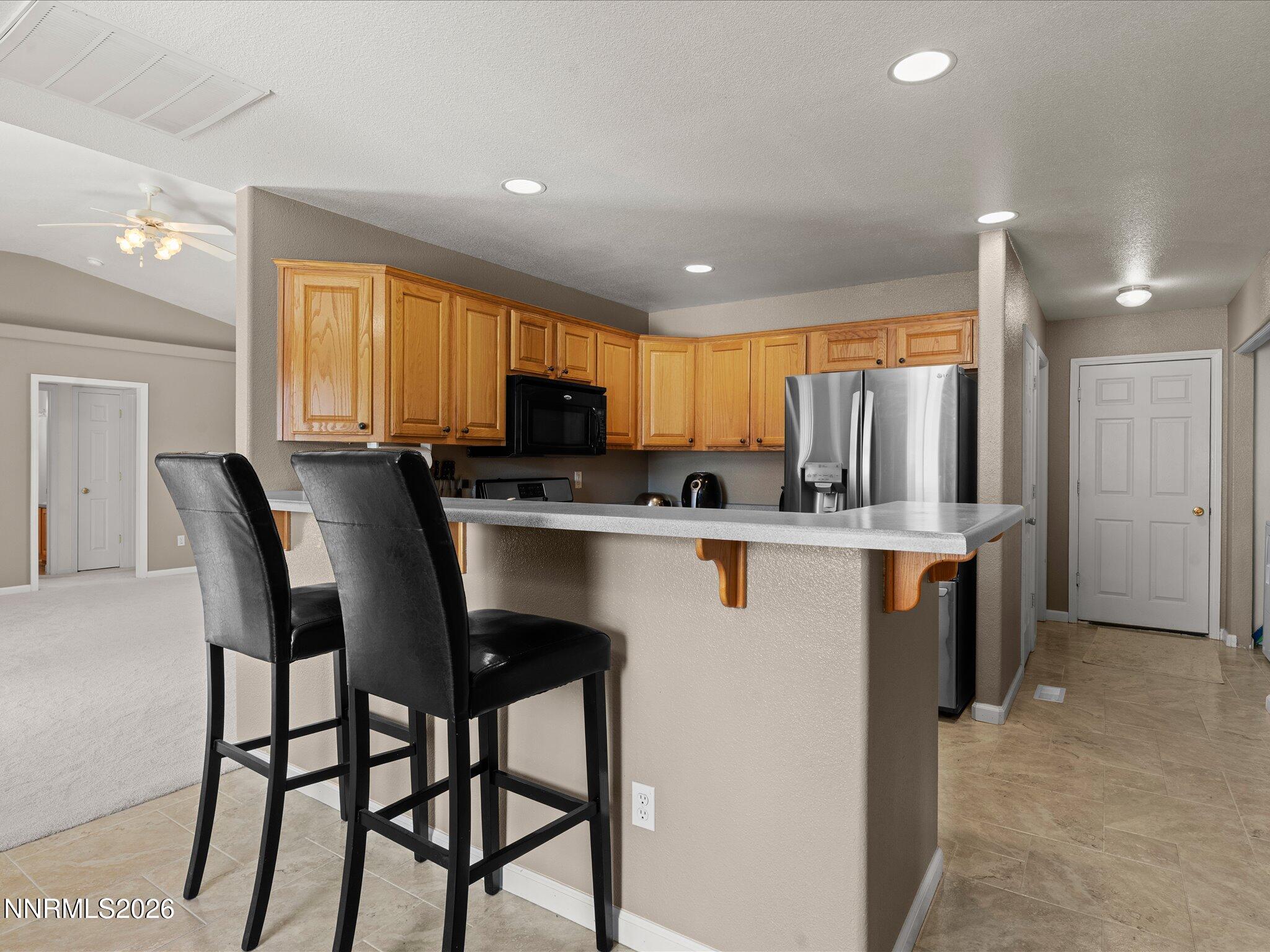 400 Bens Way Fernley, NV 89408 - Photo 12 of 31 a kitchen with stainless steel appliances kitchen island granite countertop a table chairs microwave and sink
