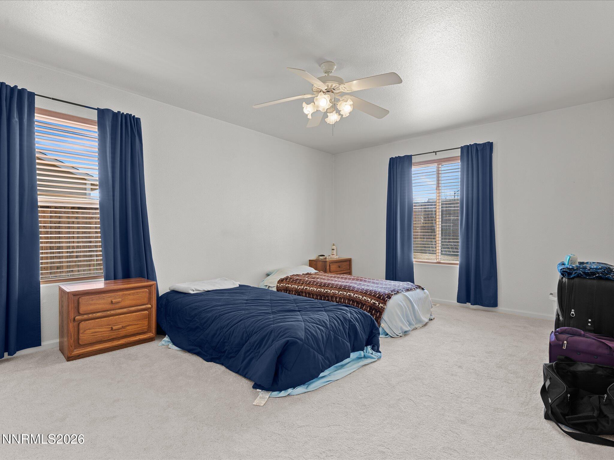400 Bens Way Fernley, NV 89408 - Photo 15 of 31 a spacious bedroom with a bed and a chandelier