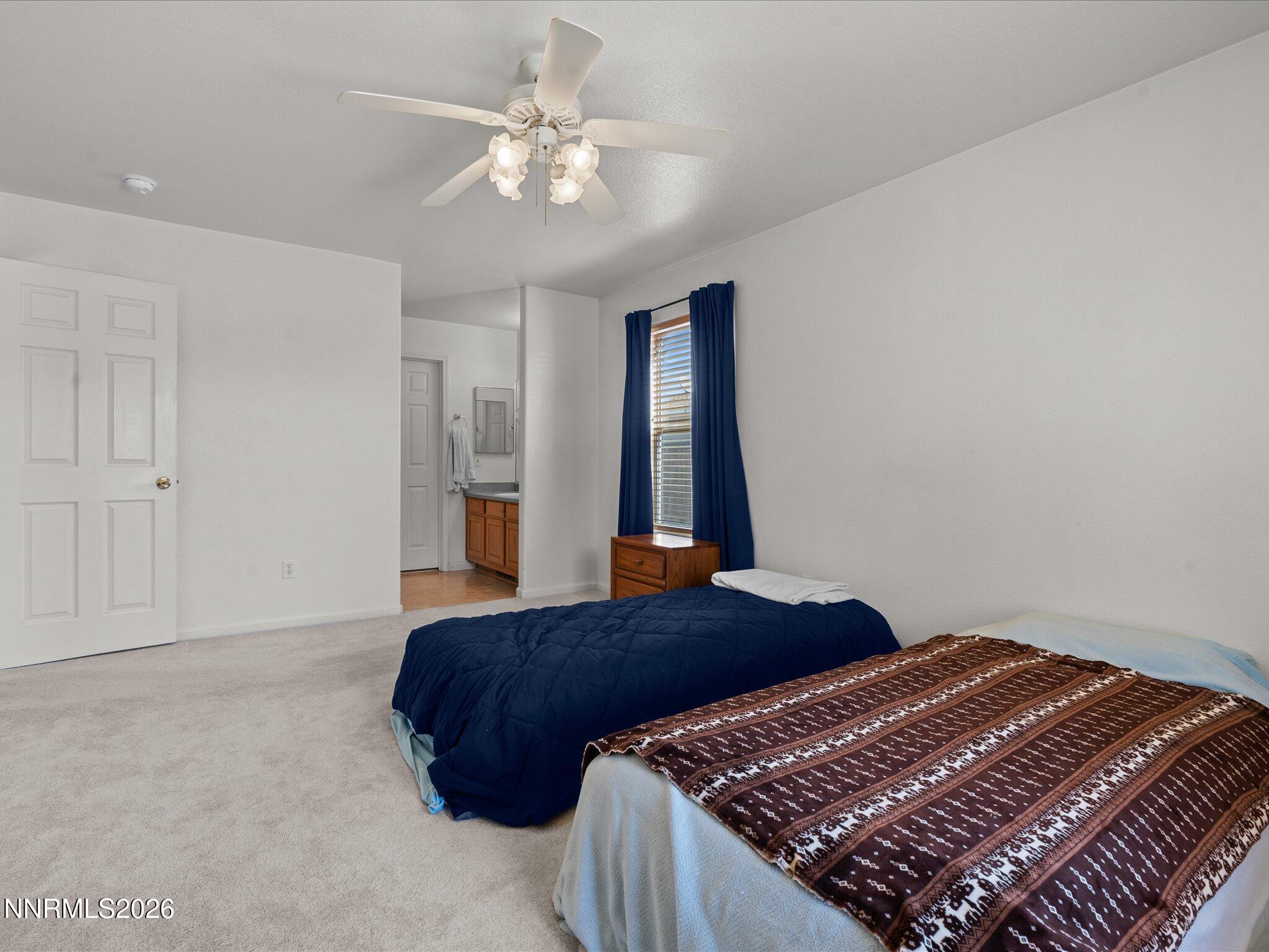 400 Bens Way Fernley, NV 89408 - Photo 16 of 31 a bedroom with a large bed and a chandelier