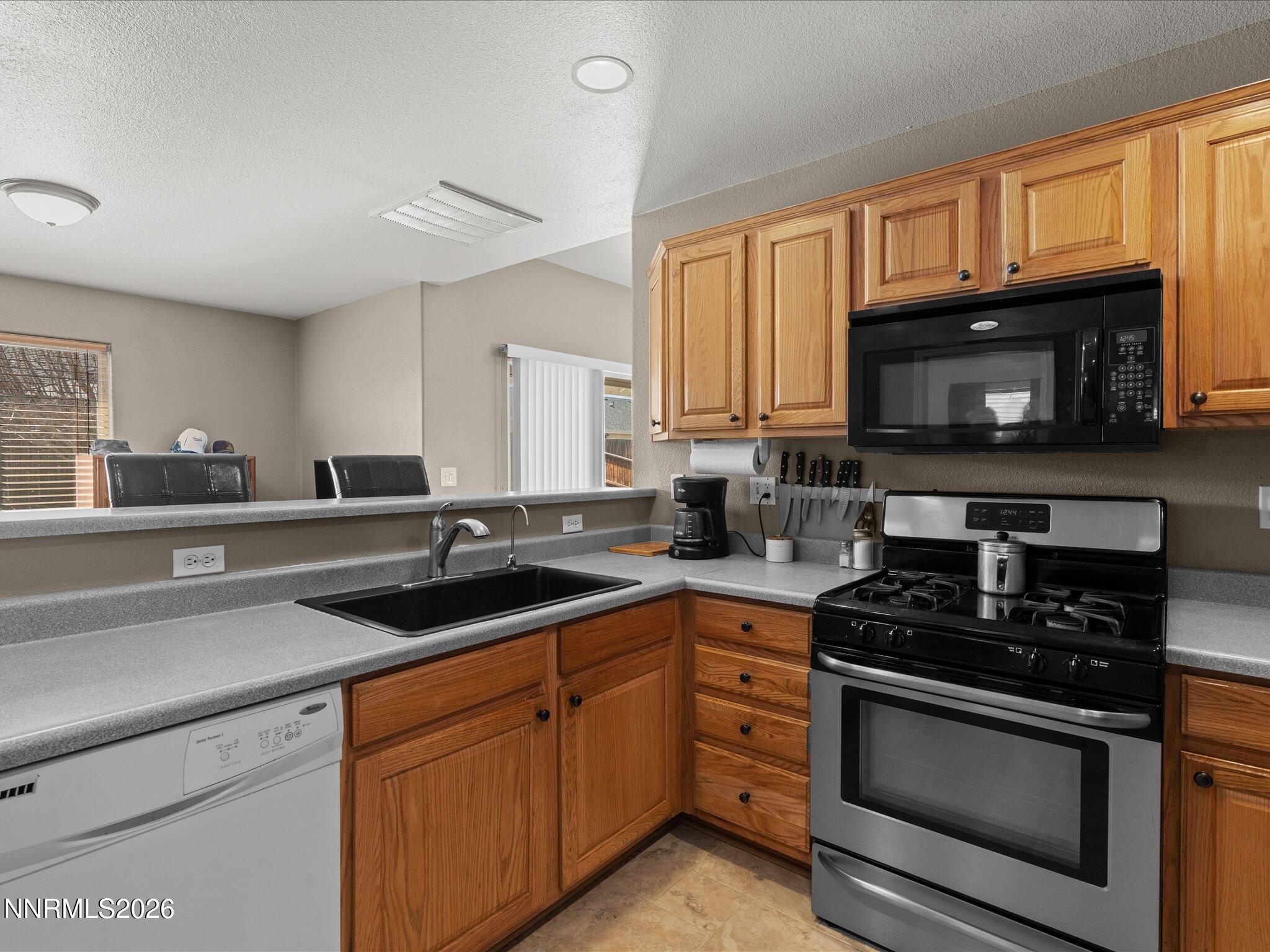 400 Bens Way Fernley, NV 89408 - Photo 10 of 31 a kitchen with stainless steel appliances a stove microwave and sink
