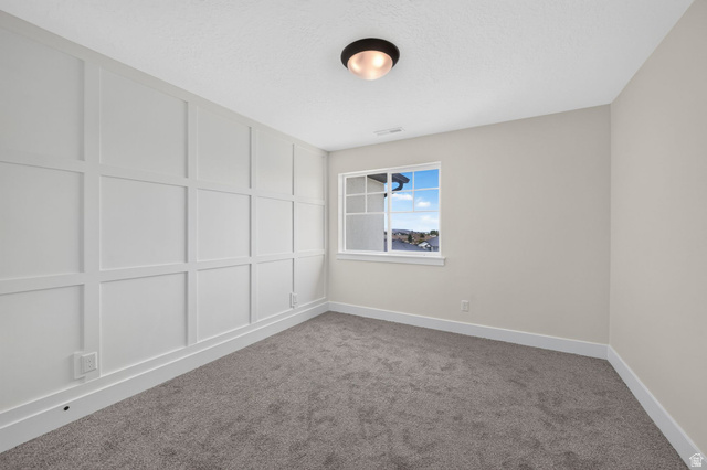 1002 West Temple Rim Lane Payson, UT 84651 - Photo 35 of 68 Interior room featuring wainscoting accent wall, neutral carpeting, window with grid panes, and flush-mount ceiling light