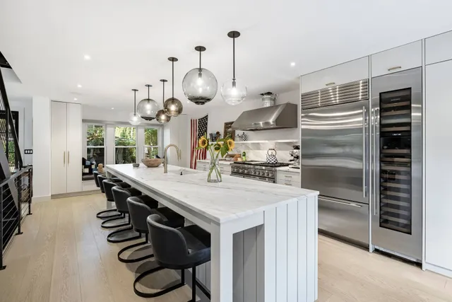 a kitchen with kitchen island white cabinets and stainless steel appliances
