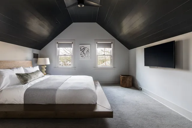 a bedroom with a large bed and a flat screen tv