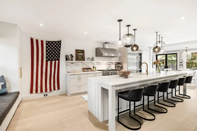 a kitchen with stainless steel appliances kitchen island granite countertop a table chairs sink and cabinets