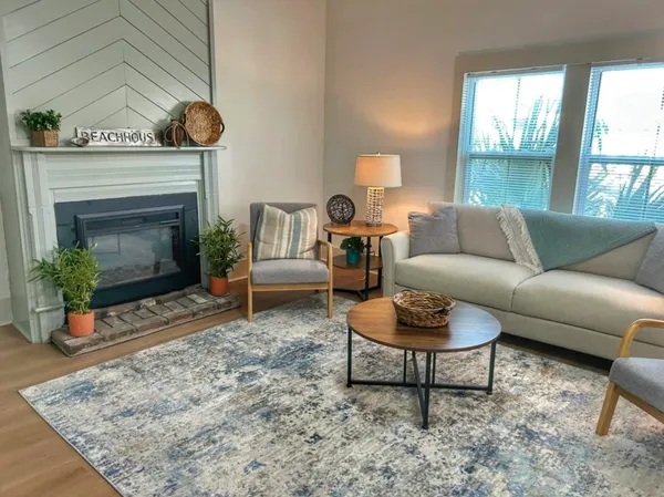 a living room with furniture a rug and a fireplace
