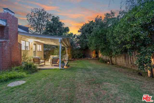 a backyard of a house with a garden and outdoor seating