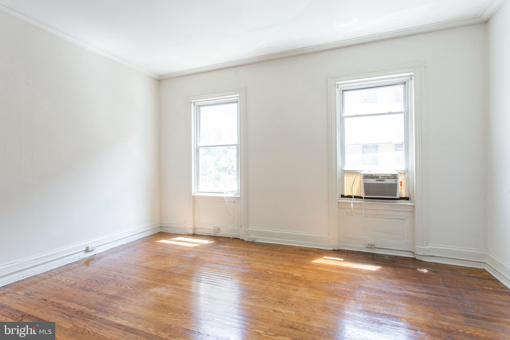 1807 Spruce Street, Unit 2F Philadelphia, PA 19103 - Photo 4 of 17 an empty room with wooden floor and windows