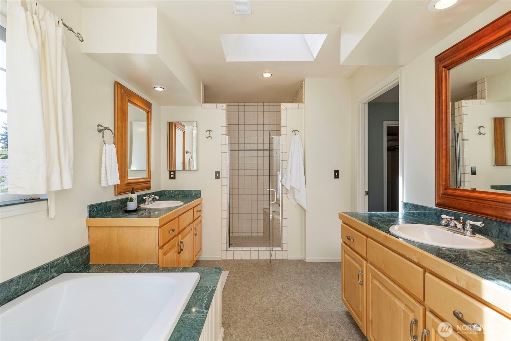 1757 Maple Street Port Townsend, WA 98368 - Photo 19 of 40 a bathroom with a granite countertop double vanity sink a mirror a bathtub and shower