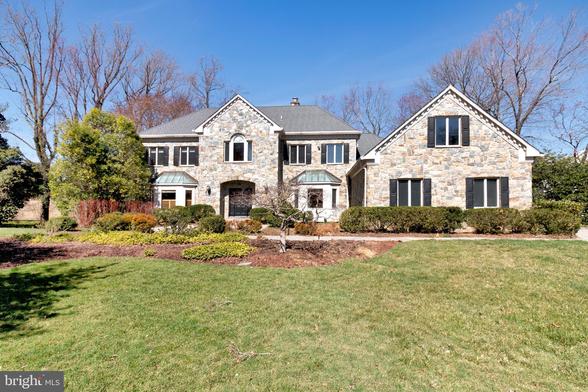 938 Douglass Drive McLean, VA 22101 - Photo 104 of 105 a view of a white house with a yard and lawn chairs under a large tree