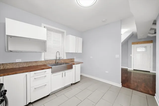 a kitchen with granite countertop white cabinets and sink