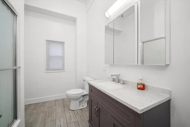 a bathroom with a sink a toilet and a mirror