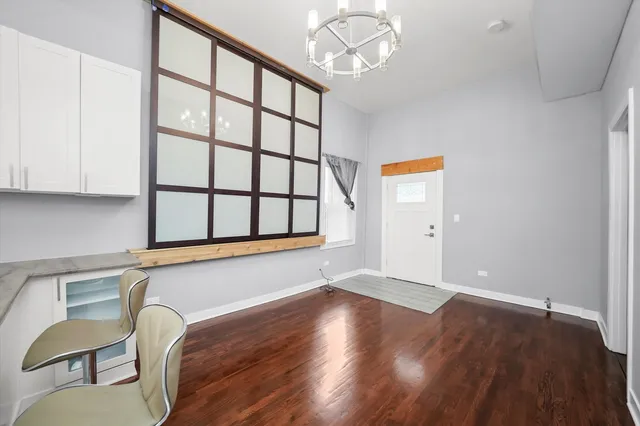 a view of a room with wooden floor chandelier windows and closet