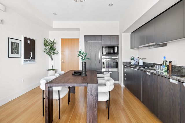 a kitchen with a table chairs refrigerator and microwave