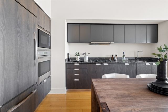 a kitchen with stainless steel appliances a stove a microwave a sink and cabinets