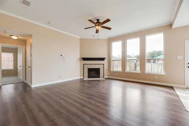 wooden floor fireplace and windows in an empty room