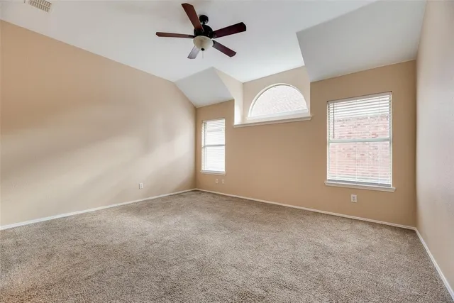 an empty room with a window and a fan