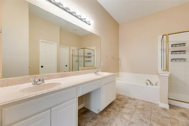 a bathroom with a tub sink and mirror