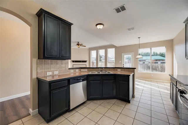 a large kitchen with granite countertop a sink and cabinets