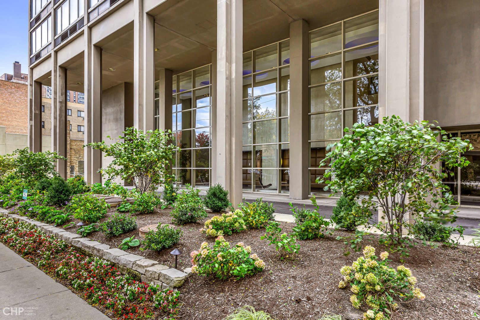 5320 North Sheridan Road, Unit 2002 Chicago, IL 60640 - Photo 2 of 57 front view of a brick house with a large windows and flower plants