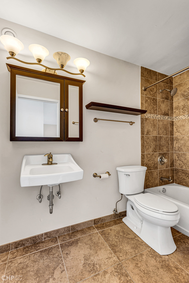 5320 North Sheridan Road, Unit 2002 Chicago, IL 60640 - Photo 31 of 57 a bathroom with a sink a toilet and mirror