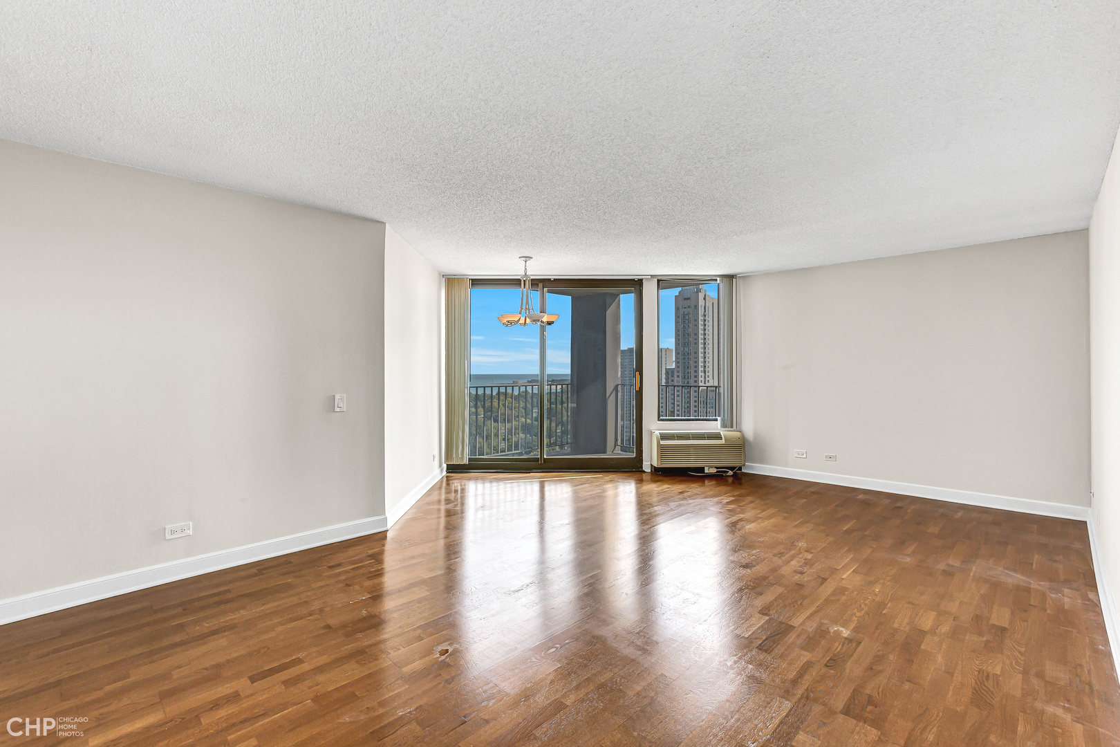 5320 North Sheridan Road, Unit 2002 Chicago, IL 60640 - Photo 4 of 57 a view of an empty room with wooden floor and a window