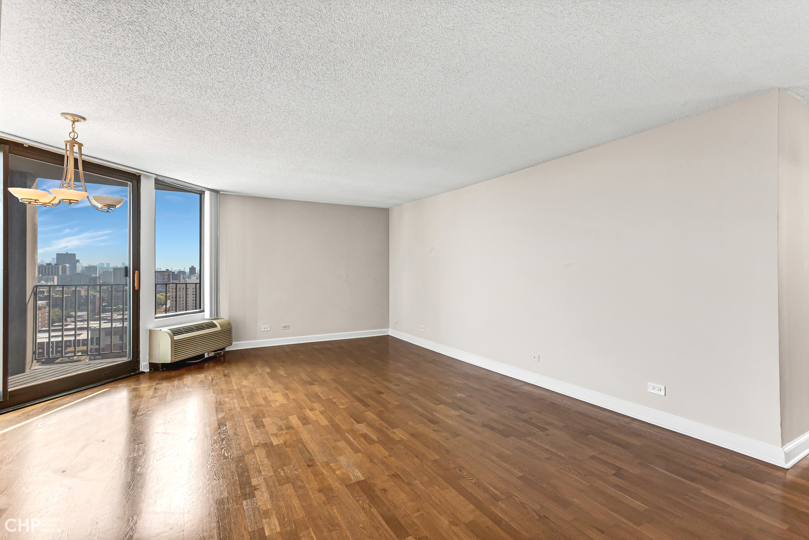 5320 North Sheridan Road, Unit 2002 Chicago, IL 60640 - Photo 5 of 57 a view of an empty room with wooden floor and a window