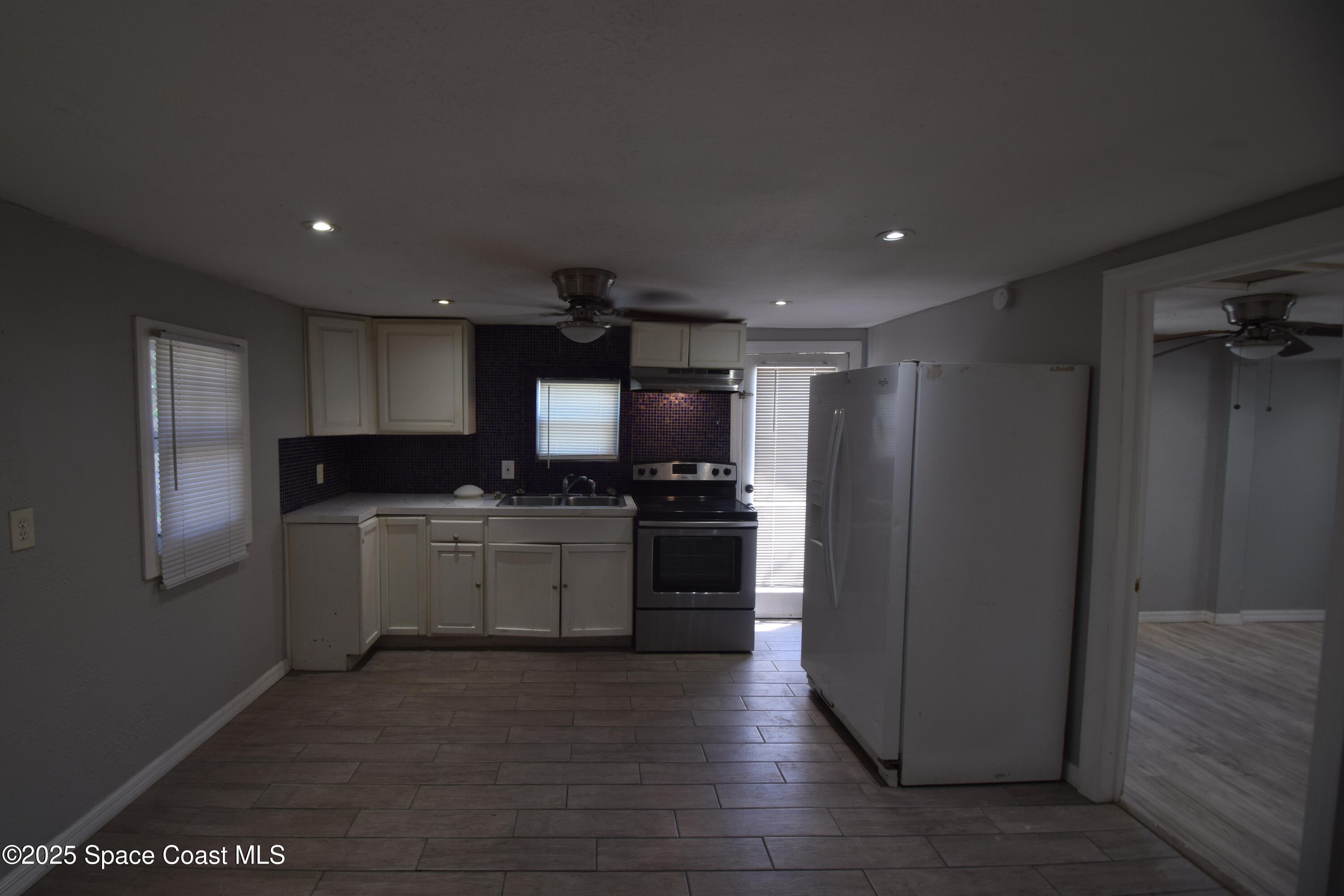 329 Pine Avenue, Unit E Cocoa, FL 32922 - Photo 4 of 11 a kitchen with a refrigerator and a stove top oven