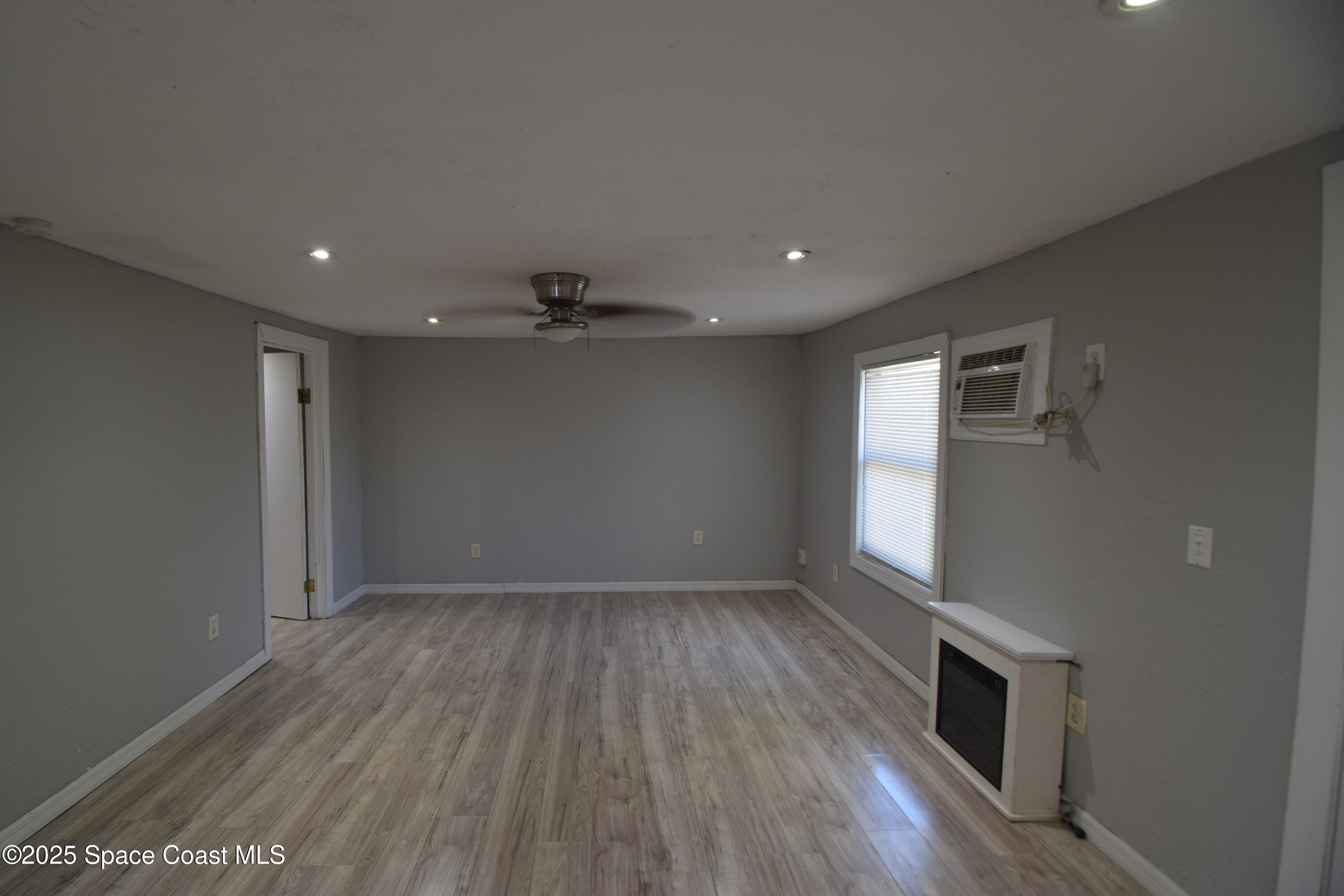 329 Pine Avenue, Unit E Cocoa, FL 32922 - Photo 5 of 11 a view of empty room with wooden floor and fan
