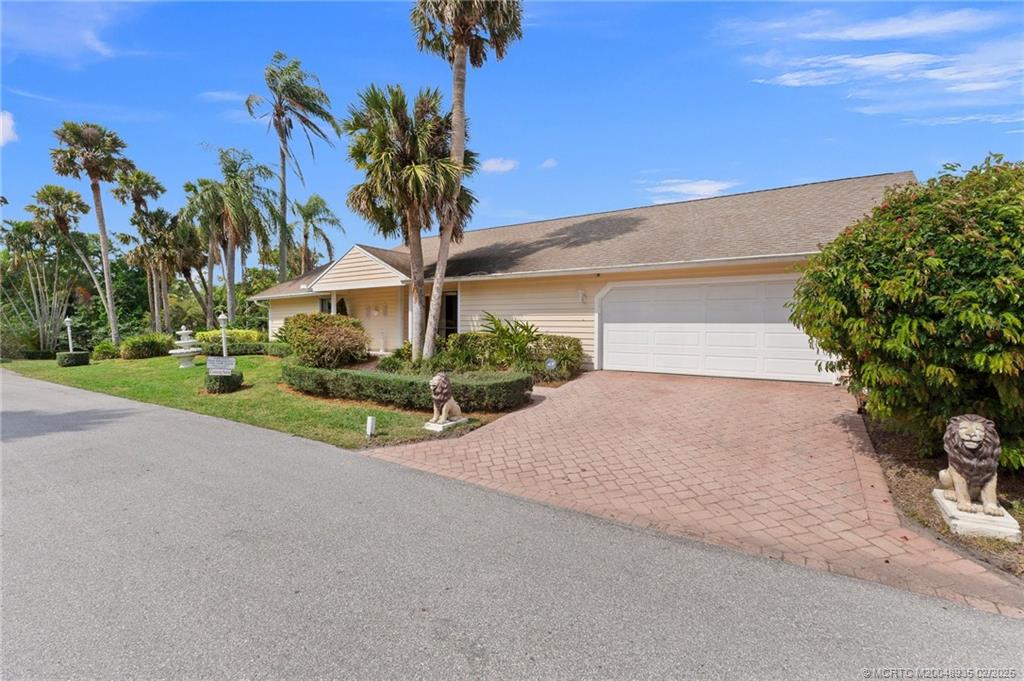 815 Southwest Salerno Road Stuart, FL 34997 - Photo 24 of 71 a front view of a house with a yard and garage