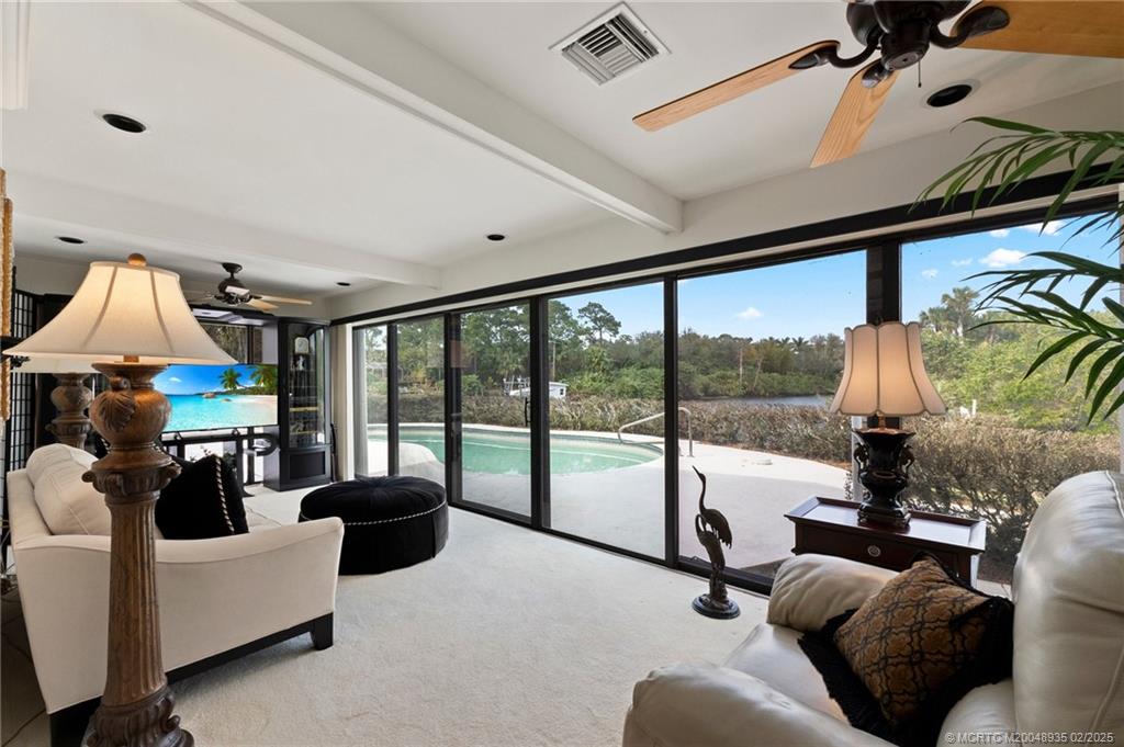 815 Southwest Salerno Road Stuart, FL 34997 - Photo 43 of 71 a living room with furniture and a floor to ceiling window