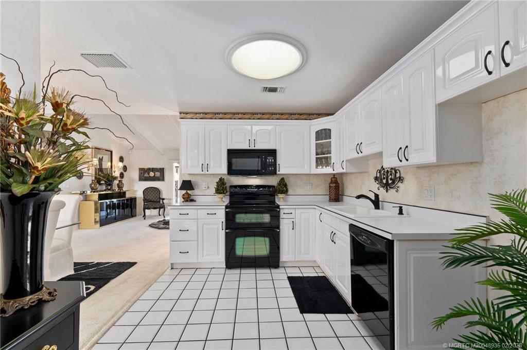 815 Southwest Salerno Road Stuart, FL 34997 - Photo 50 of 71 a kitchen with a sink stainless steel appliances and white cabinets