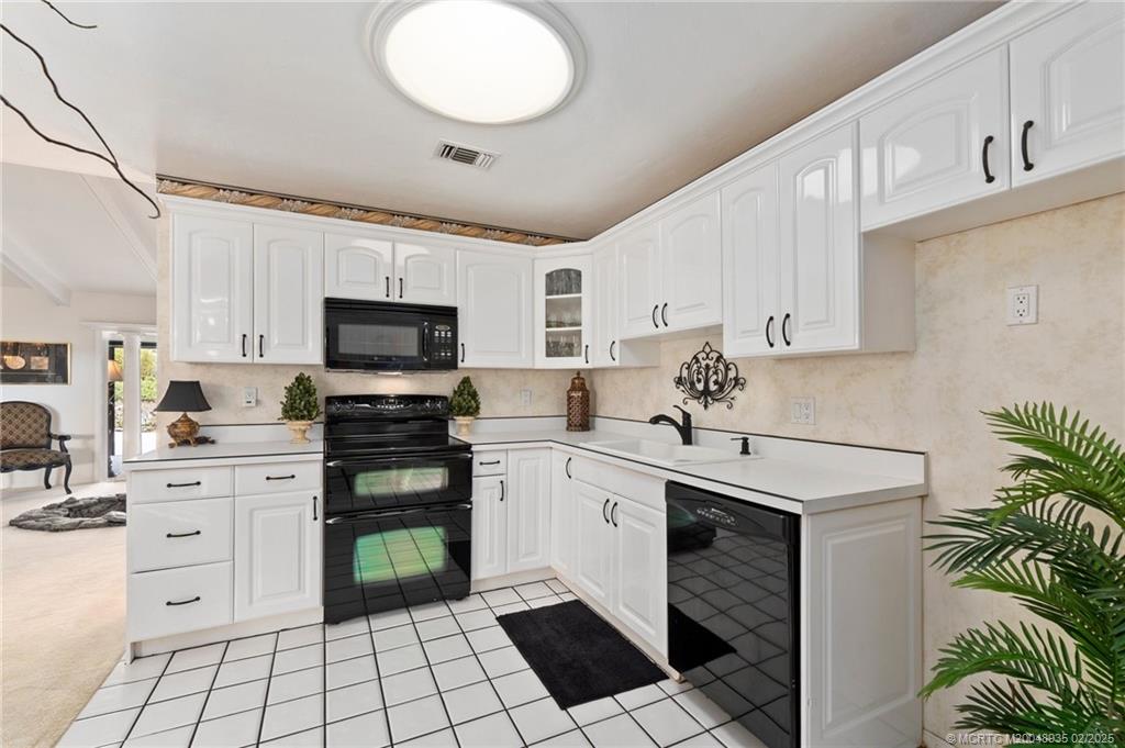 815 Southwest Salerno Road Stuart, FL 34997 - Photo 51 of 71 a kitchen with a sink white cabinets and appliances