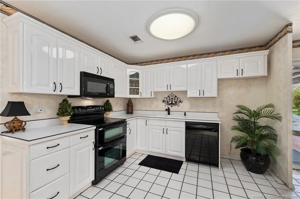 815 Southwest Salerno Road Stuart, FL 34997 - Photo 52 of 71 a kitchen with a sink a stove top oven and cabinets