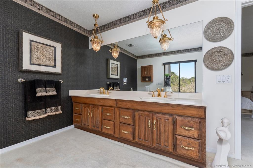 815 Southwest Salerno Road Stuart, FL 34997 - Photo 62 of 71 a spacious bathroom with a double vanity sink and a mirror
