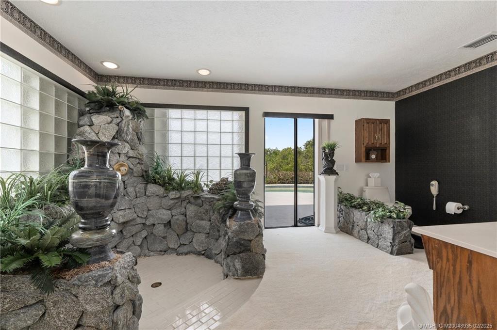 815 Southwest Salerno Road Stuart, FL 34997 - Photo 64 of 71 a spacious bedroom with a large bed and a potted plant