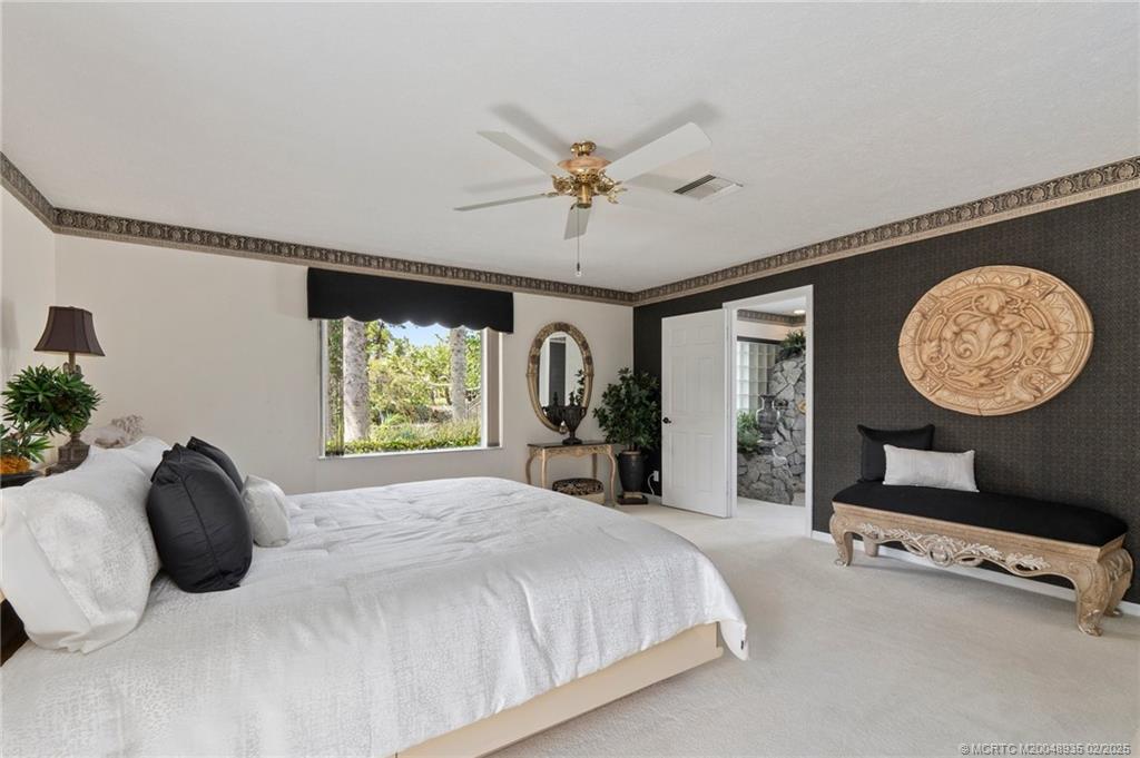 815 Southwest Salerno Road Stuart, FL 34997 - Photo 65 of 71 a bedroom with a bed and a chandelier