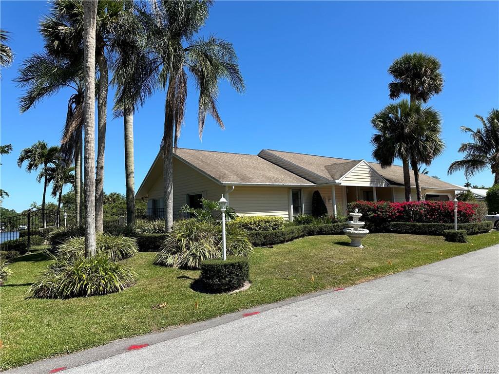815 Southwest Salerno Road Stuart, FL 34997 - Photo 71 of 71 a front view of a house with garden and trees