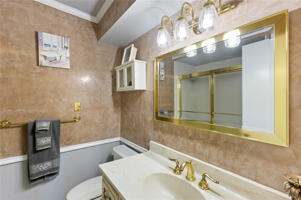 2402 Scott Mill Road Carrollton, TX 75006 - Photo 14 of 20 a bathroom with a sink a toilet and mirror