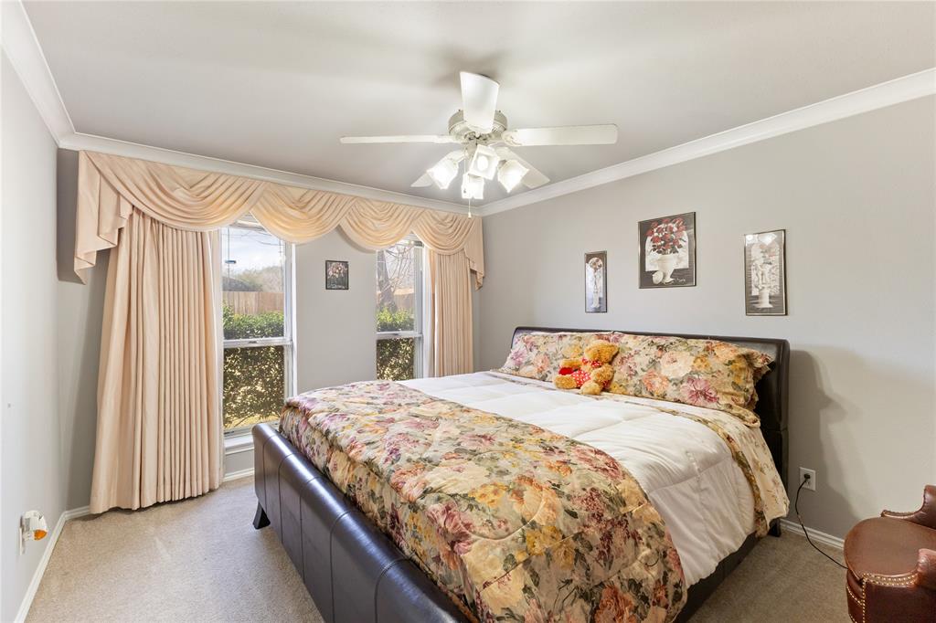 2402 Scott Mill Road Carrollton, TX 75006 - Photo 16 of 20 a bedroom with a large bed and a chandelier