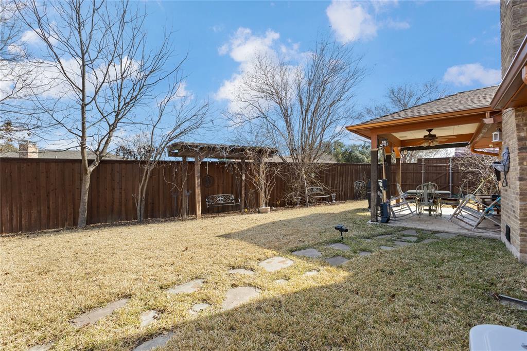 2402 Scott Mill Road Carrollton, TX 75006 - Photo 18 of 20 a view of a backyard with large trees and wooden fence