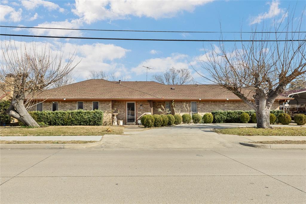 2402 Scott Mill Road Carrollton, TX 75006 - Photo 2 of 20 a front view of a house with a yard and garage