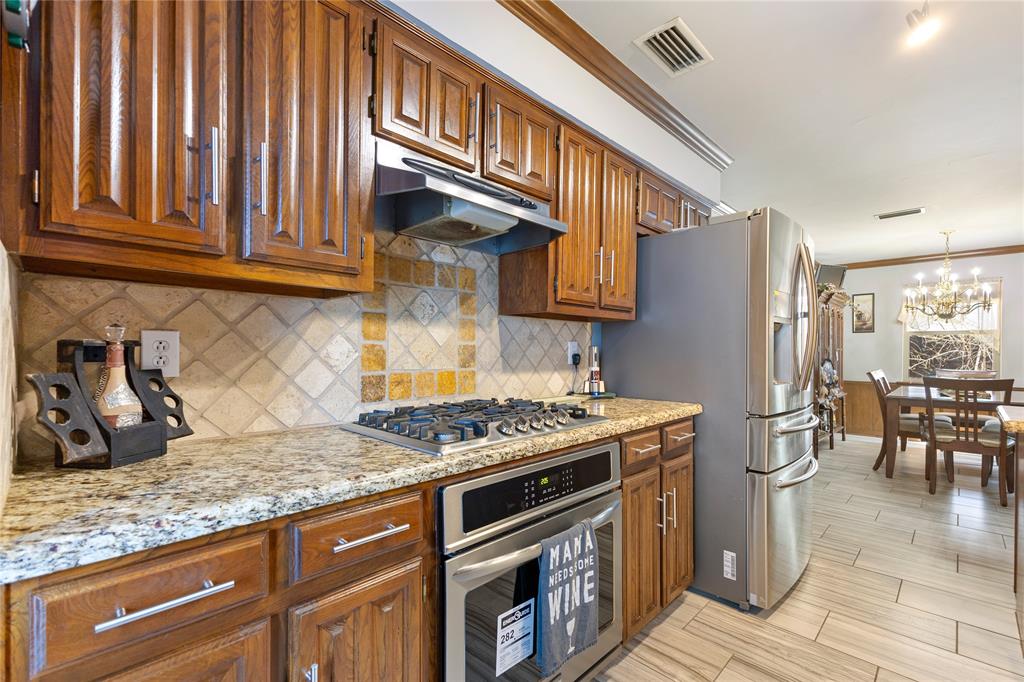 2402 Scott Mill Road Carrollton, TX 75006 - Photo 4 of 20 a kitchen with stainless steel appliances granite countertop a stove a sink and a microwave