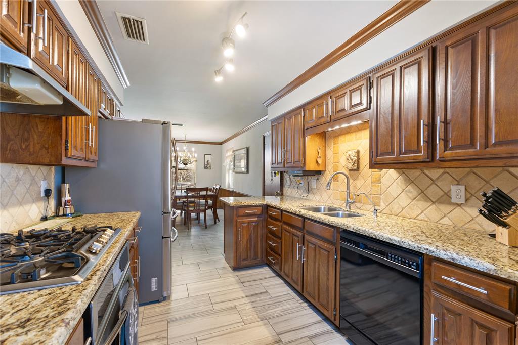 2402 Scott Mill Road Carrollton, TX 75006 - Photo 5 of 20 a kitchen with stainless steel appliances granite countertop sink stove top oven and cabinets