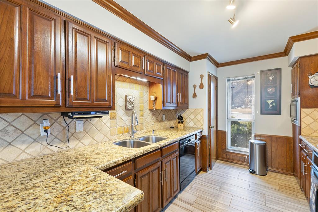 2402 Scott Mill Road Carrollton, TX 75006 - Photo 6 of 20 a large kitchen with stainless steel appliances granite countertop a sink stove and wooden cabinets
